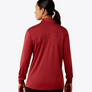 Back view of a person wearing a dark red long sleeve shirt against a light grey background.