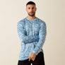 Man wearing a blue camo long sleeve t-shirt with a beige background