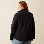 Back view of a person wearing a black jacket against a beige background.