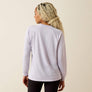 Person wearing a light purple long-sleeve shirt on a beige background