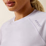 Close-up of a person wearing a light purple long sleeve Ariat T-shirt