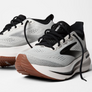 White running shoes with black laces and brown heel accents on a white background