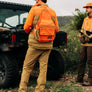 Person wearing hunting gear in a field.