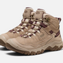 A pair of tan boots with dark purple accents and a light brown sole with the Keen logo on the side of it.