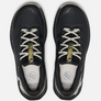 Top view of a pair of black shoes with white laces and green accent on the tongue against a white background.