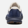 Back view of a dark blue shoe that has white accents against a white background.