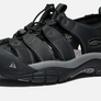 Angled side view of a black sandal with grey accents and the Keen logo on the side against a white background.