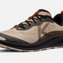 Side view of a tan shoe that has dark brown and burnt orange accents with a large light brown letter K on the side of the shoe.