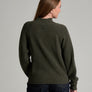 Back view of a person in a dark green sweater against a grey background.