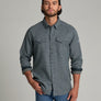 Person wearing a dark blue long sleeve button up shirt with a collar.