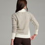 Back view of a person wearing a natural colored sweater against a grey background.