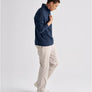 Person wearing a navy blue long sleeve and white pants against a white background.