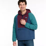 Person wearing a multi-colored 1/4 zip jacket with a hood against a white background.