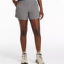 Person wearing gray shorts and hiking boots on a white background