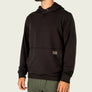 Person wearing a black hoodie and green pants against a white background.