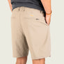 Beige shorts worn by a person on a light gray background