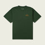 Dark green t-shirt that has Marsh Wear written on the front left side of the shirt where a pocket would go against a beige background.