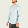 Man wearing a light blue long-sleeve shirt with a brand logo on a white background