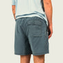 Person wearing blue shorts and a light blue shirt on a plain background