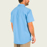 Man wearing a light blue shirt with a collar on a beige background