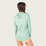 Person wearing a frosty green long sleeve with a hood on a blank background