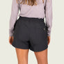 Person wearing grey shorts with a pocket on the back against a white background