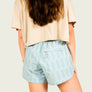Back view of person wearing frosty green shorts on a plain background