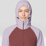 Person wearing a two-tone hoodie with a light purple hood and maroon body on a white background