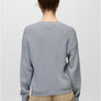 Back view of a person wearing a light grey sweater with khaki pants against a white background.