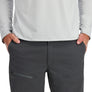 Person wearing a light gray long-sleeve shirt and dark gray pants with a brand logo.
