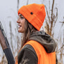 Person wearing a bright orange hat and vest outside.