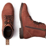Top view of a boot standing up and another one laying on its side against a white background.