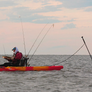 Person in a kayak using a ParkNPole in a kayak on water with a sunset in the background