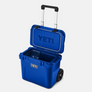 Open royal blue cooler with a handle and wheels . It also has the Yeti logo on the front and the inside of the lid.