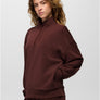 Person wearing a dark maroon sweat suit where the sweatshirt zips half the way against a grey background.