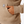 Close up image of a person wearing a tan sweatshirt and a person putting their hand into the pocket.