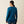 Back view of a person wearing a dark blue shirt with Ariat written in light blue going down the arm of the sleeve.