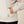 Close up view of a person putting their hand into the pocket of a shirt and have a brand tag right below the pocket.