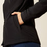 Close up image of a person putting their hand into a black jacket pocket