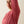A person wearing a pink shirt with their arm raised to show the breathable fabric in the arm pit of the shirt.