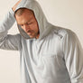 Man wearing a gray hoodie with a brand logo on a plain background