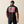 Man wearing a black t-shirt with 'Ariat Work' design on the back, standing against a beige background.