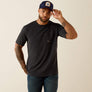 Man wearing a black t-shirt and blue jeans with a cap on a beige background