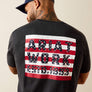 Man wearing a black t-shirt with 'Ariat Work' design on the back against a beige background