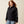 Person wearing a black jacket that says Ariat down the arm in white.