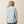 Person wearing a light blue shirt on a beige background
