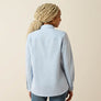 Person wearing a light blue shirt on a beige background