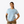 Person wearing a light blue t-shirt with a logo on a white background