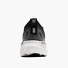 Back view of a black, grey and white shoe against a white backgorund