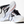 White, black and rose gold running shoes with the brooks logo on a white background